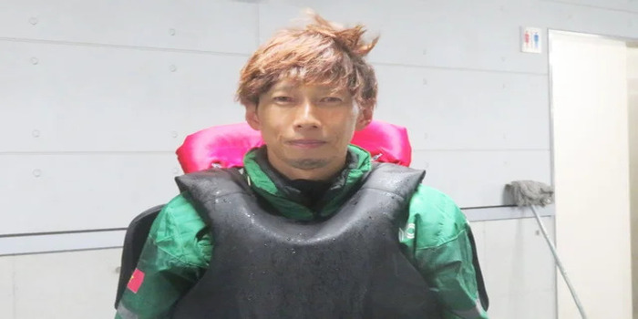 Tangkapan layar dari akun resmi Yahoo Japan, menampilkan Yoshitsugu Yoshikawa dengan ekspresi tenang dan penuh konsentrasi dalam balutan seragam balap hijau dan pelampung hitam, mencerminkan kesiapan.