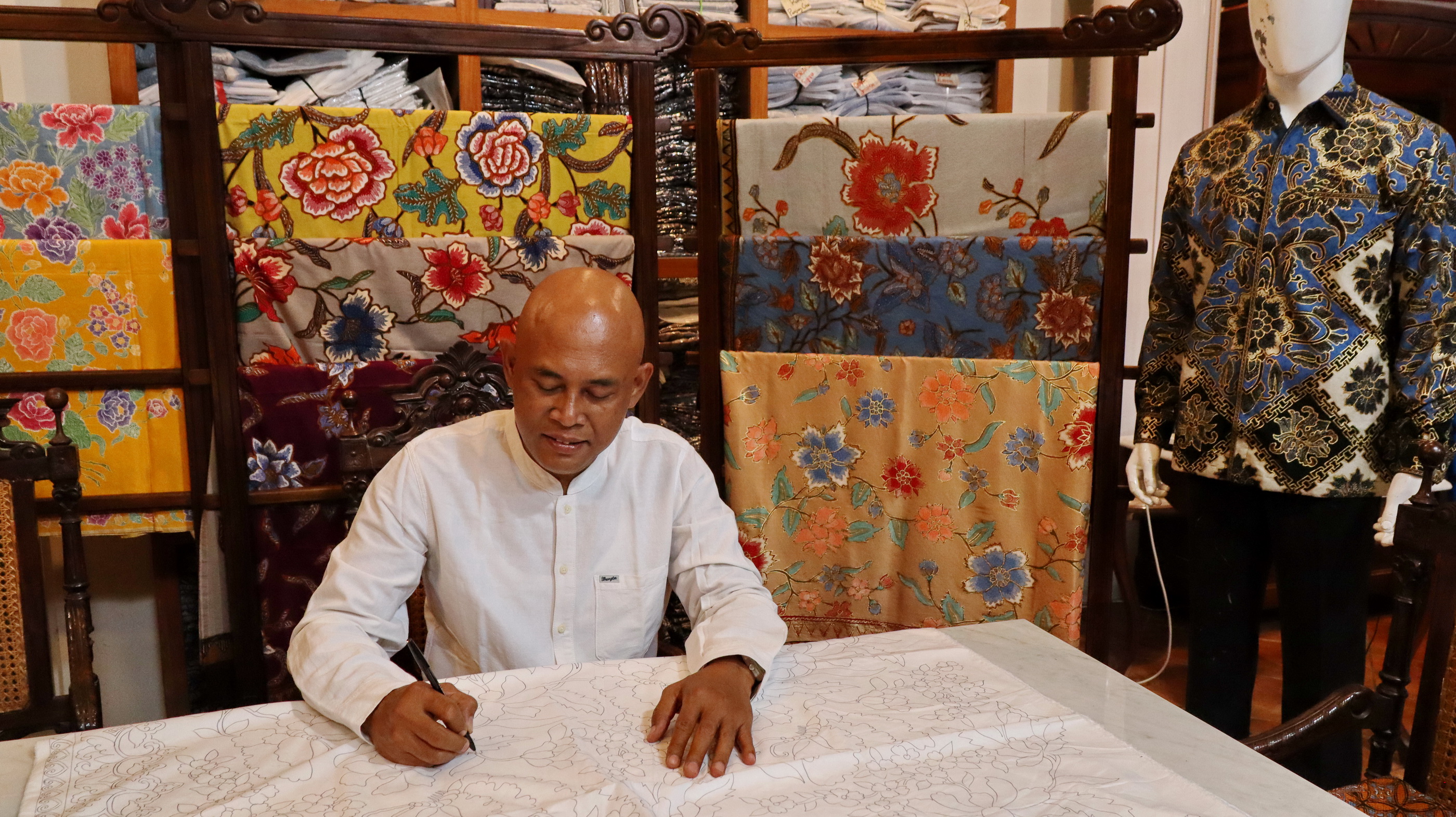 MEMBUAT POLA BATIK - Pemilik Perada Batik, Syamsul Huda turun langsung membuat pola batik, sebelum dilakukan prose mencanting oleh para pengrajinnya, di galerinya, Krapyak Pekalongan Utara.