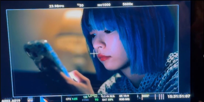 Tangkapan layar dari akun Instagram @narumi_05, menampilkan seorang dirinya dengan rambut bob berwarna biru yang sedang menatap layar ponselnya dengan ekspresi serius dan fokus.