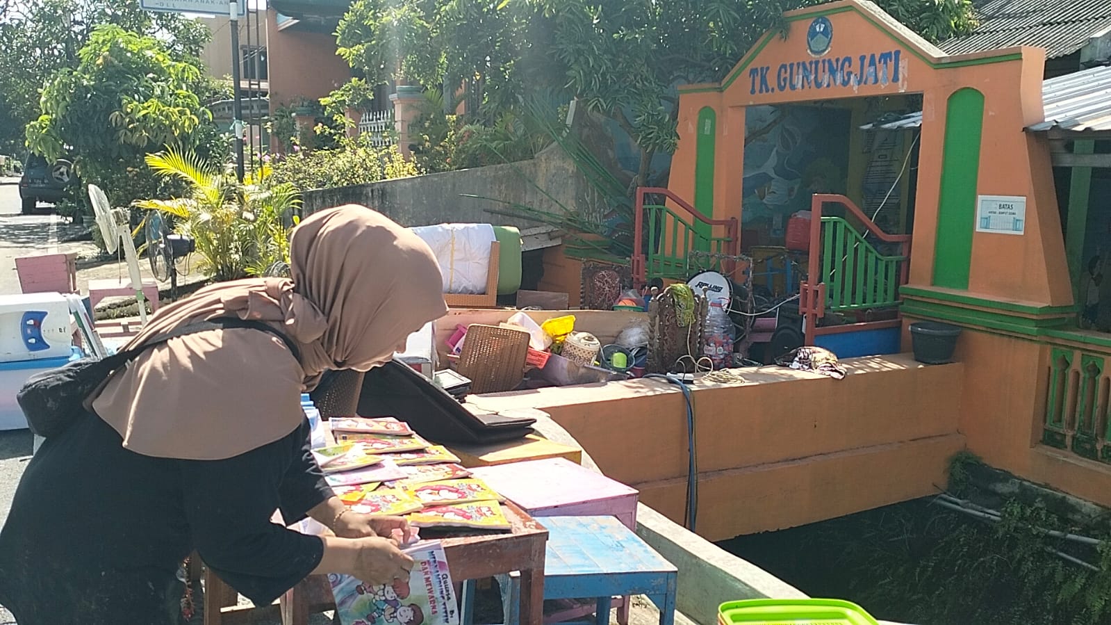 Guru menata peralatan sekolah di TK Gunungjati yang berlumpur, Jumat (16/1)