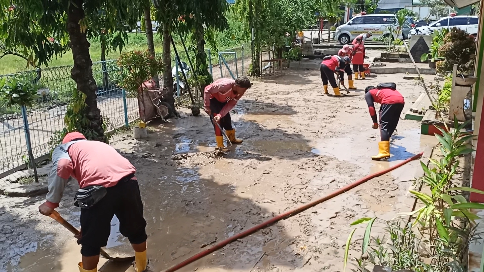BERSIHKAN SISA BANJIR : Petugas Damkar bersama warga bahu membahu membersihkan Sekolah yang terendam banjir.