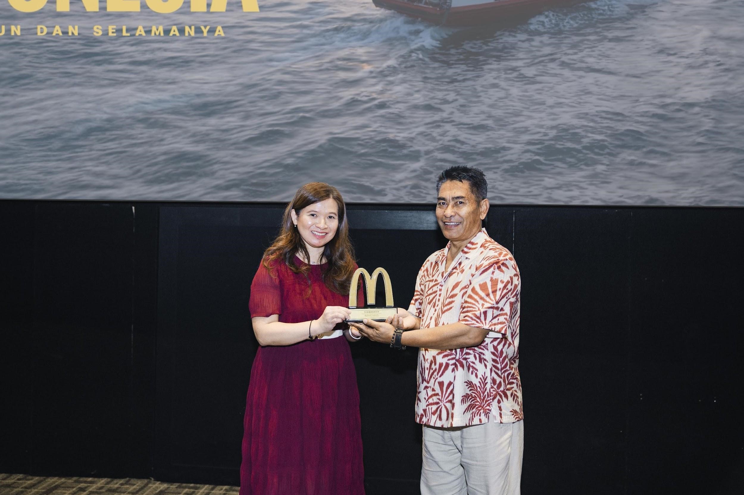 Caroline Kurniadjaja dari McDonald&rsquo;s Indonesia memberikan plakat penghargaan kepada Made Gunada selaku mitra pemasok asal Bali yang telah menjalin kemitraan dengan McDonald&rsquo;s Indonesia sejak 1993.