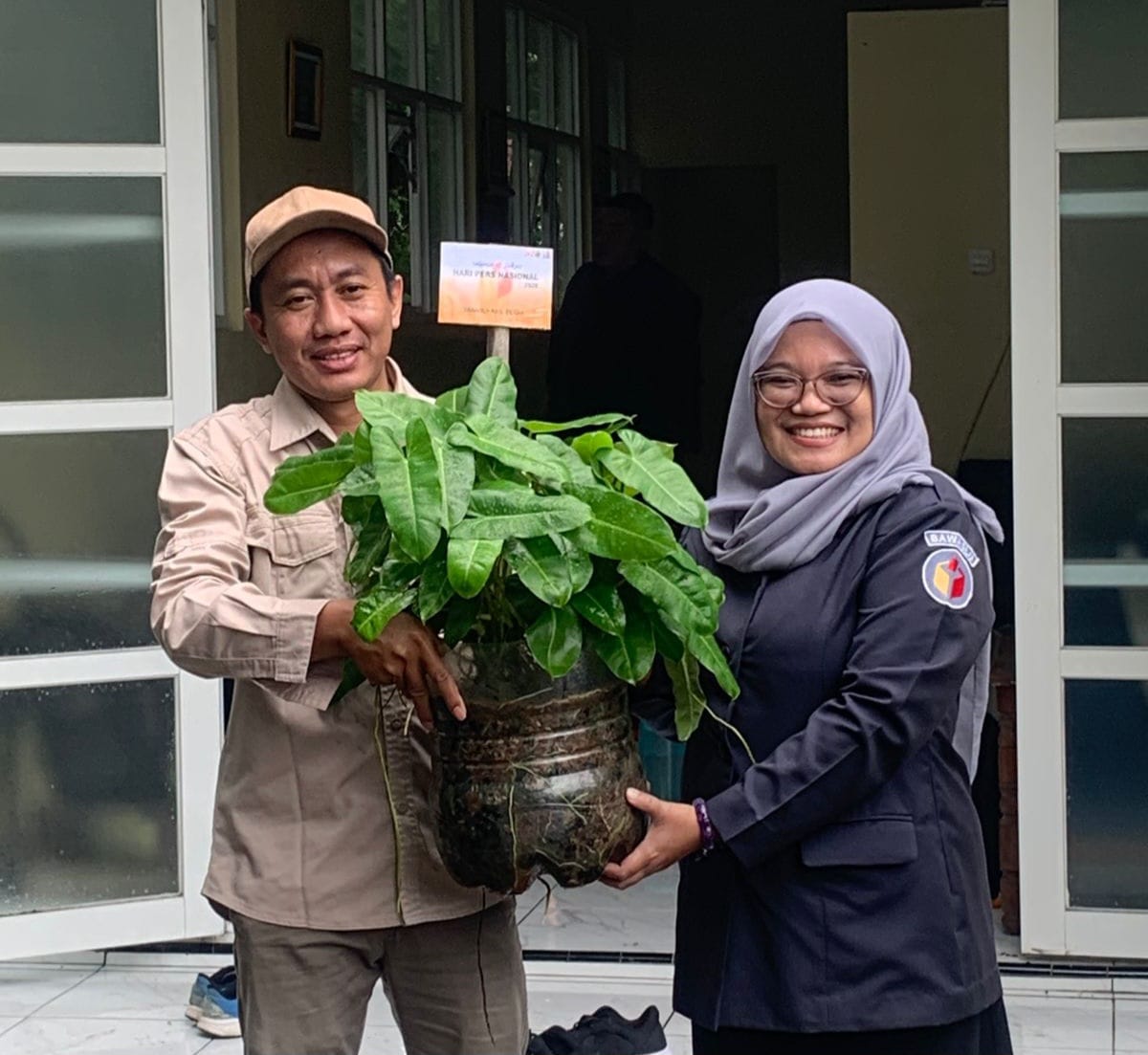 Ketua PWI Demak Wahib Pribadi menerima bunga ucapan selamat Hari Pers Nasional 2026 dari komisioner Bawaslu Demak Kusfitria Martiyasih. (Wahibpribadi)