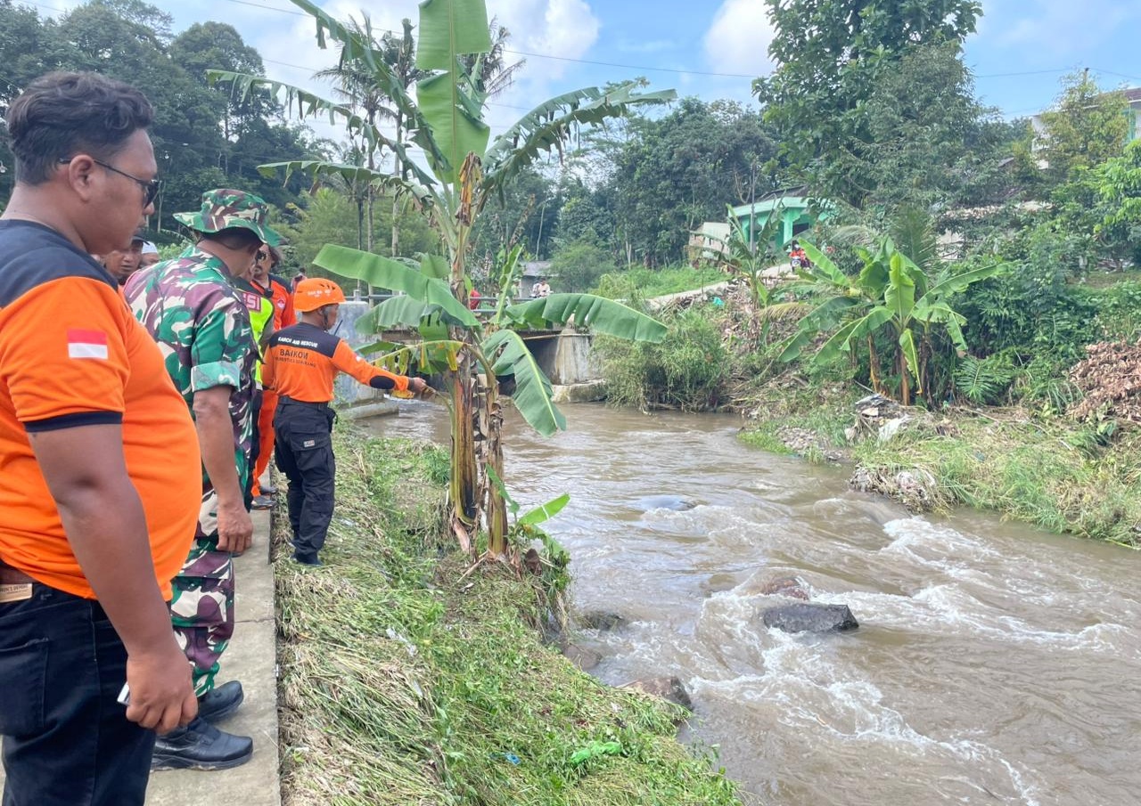 Anggota tim SAR gabungan saat melakukan pencarian korban pengendara motor yang terseret arus sungai di Kalimalang Mijen