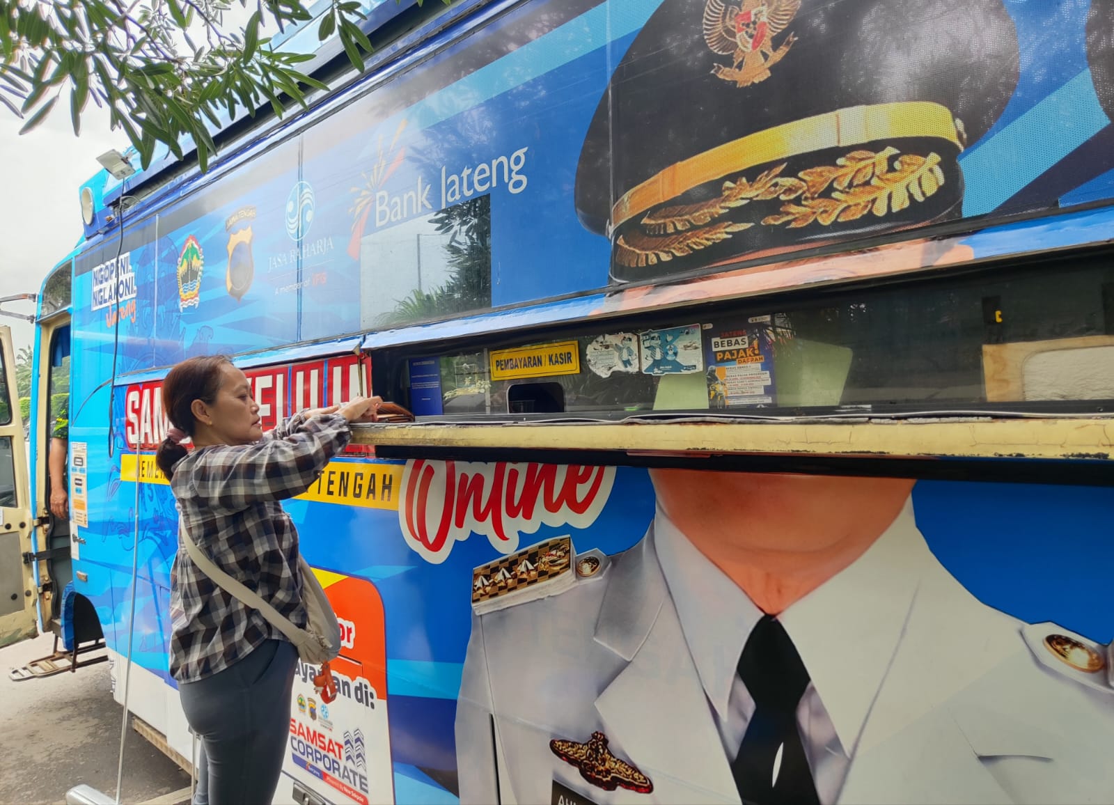 Seorang warga sedang membayar pajak di Samsat Keliling Simpang Lima Semarang.