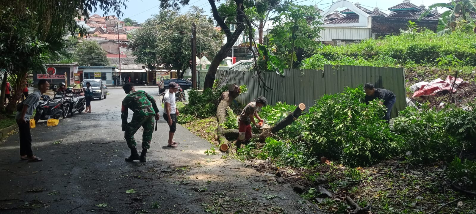 Petugas tengah memotong dan membersihkan sebuah pohon yang tumbang di Jalan Merapi, Rabu siang (18/2/26). (Sulistiono)