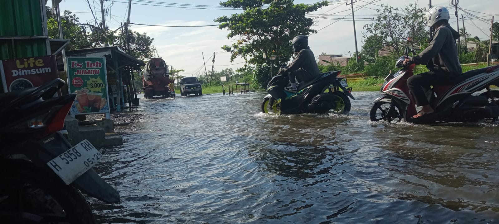 Pengendara motor tampak beriringan melaju melewati genangan banjir di wilayah Ngablak, Muktiharjo, Kamis pagi (5/3/26). (Sulistiono)