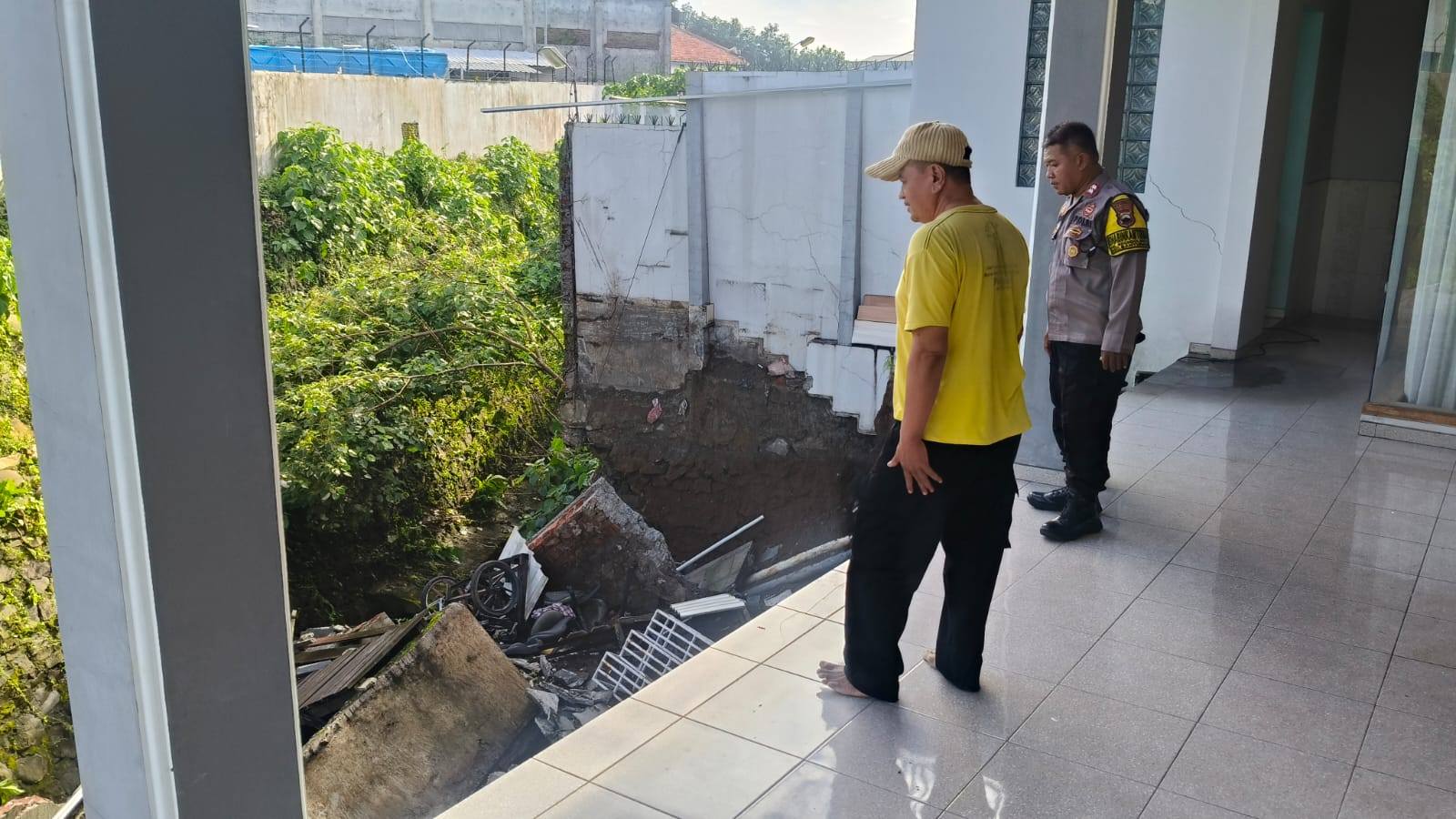 Warga dan aparat kepolisian melihat kondisi longsor dikompleks Perumahan Alam Firdaus. 