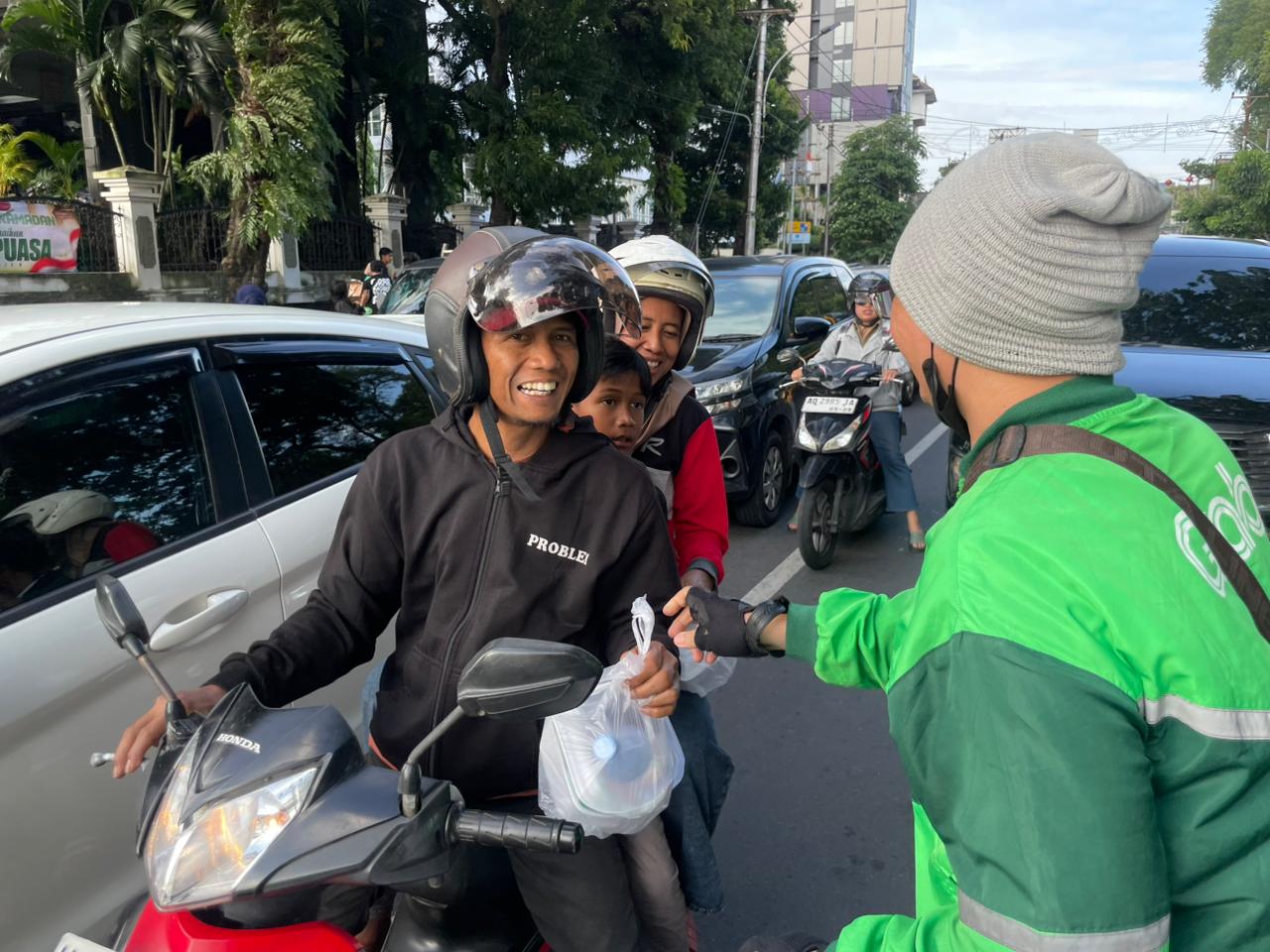 Mitra Pengemudi Grab membagikan takjil kepada pengguna jalan yang melintas di sekitar Tugu Muda dan Lawang Sewu, Semarang.&nbsp;