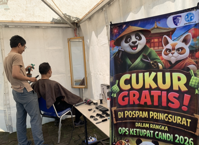  Seorang pemudik menikmati layanan cukur rambut gratis di Pos Pengamanan Pringsurat, Selasa (17/3).