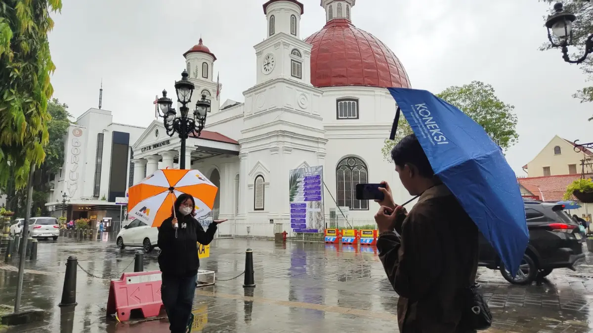 
BERGAYA DULU : Wisatawan di Kota Lama tetap antusias hunting foto meski hujan lebat. (KHAFIFAH ARINI PUTRI/JAWA POS RADAR SEMARANG)