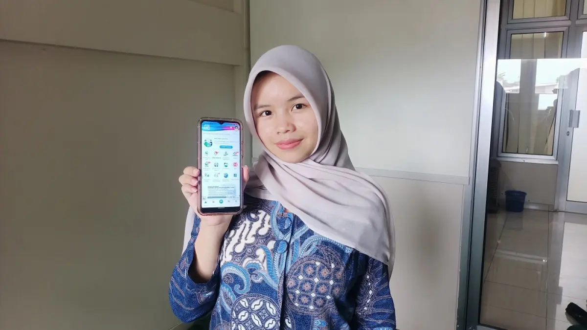 Okta Fiya Bela dengan aplikasi Mobile JKN-nya. (ISTIMEWA)