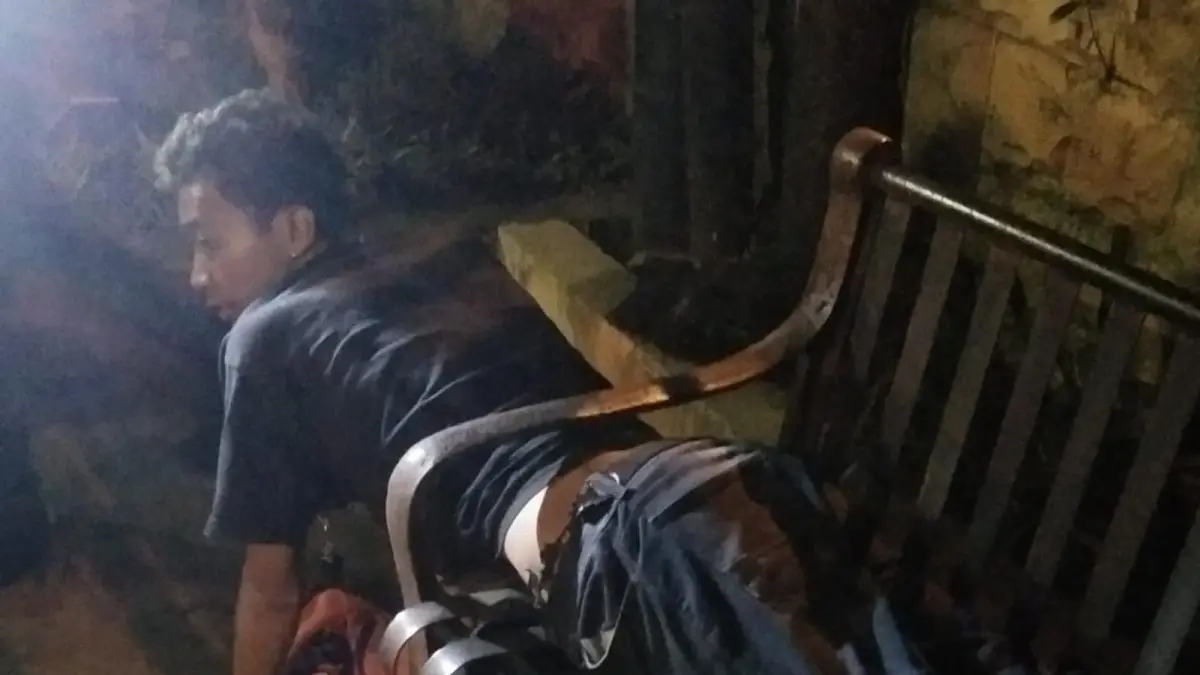 Seorang warga bernama Iwan, asal Kemiri, harus dievakuasi petugas pemadam kebakaran setelah tubuhnya terjebak di kursi besi tempat ia tertidur.