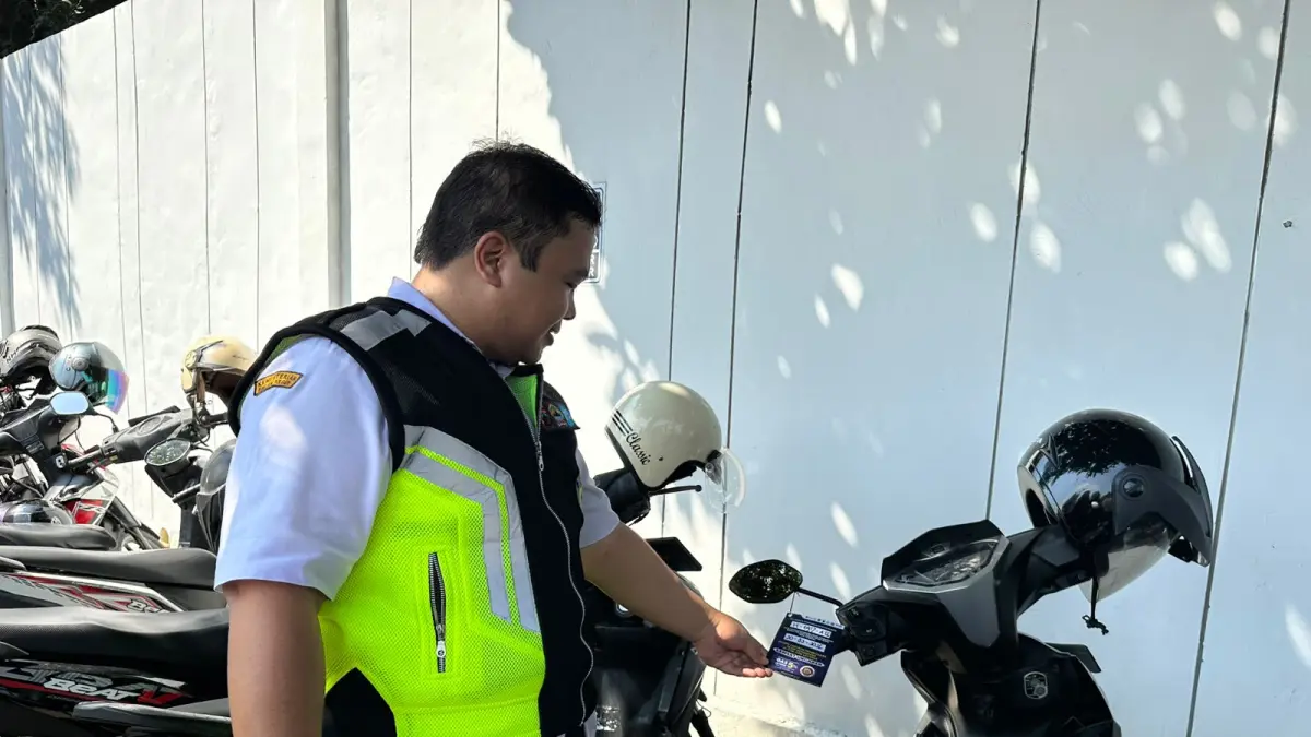 Petugas Samsat Ungaran, Kabupaten Semarang, Jawa Tengah saat lakukan penempelan surat keterangan bahwa motor tersebut belum membayarkan pajak tahunan di Kantor Setda Kabupaten Semarang. Rabu (13/5)
