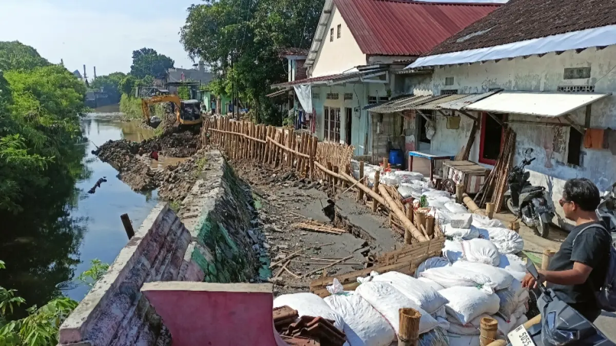 MULAI PENANGANAN : Amblasnya tanggul dan jalan di Jembawan I Kalibanteng Kulon, mulai dilakukan perbaikan oleh BBWS, dan DPU Kota Semarang. (ADENNYAR WYCAKSONO/ JAWA POS RADAR SEMARANG)