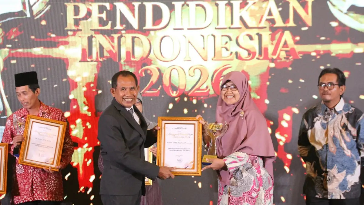 Kepala SMP IT Bina Amal Tiara Pangesti Dewi, S.Pd. menerima piala dan piagam yang diserahkan Direktur Jawa Pos Radar Semarang H. Baehaqi. (BASKORO SEPTIADI/JAWA POS RADAR SEMARANG)
