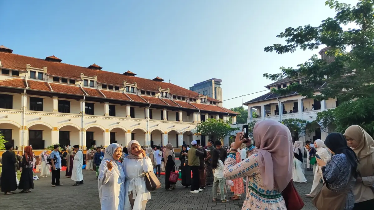 Pelancong hunting foto usai menunaikan salat Iduladha di Lawang Sewu, Rabu (27/5).