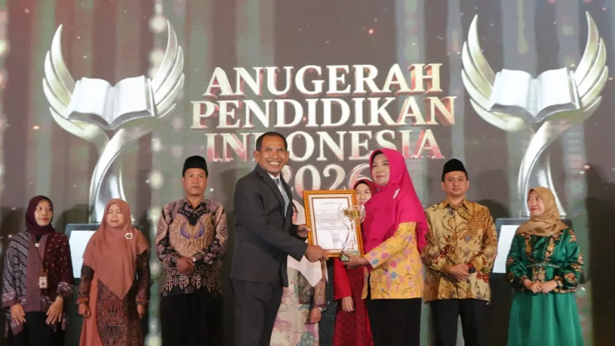 Kepala SD Negeri 01 Batursari, Kecamatan Talun, Kabupaten Pekalongan, Endang Purwanti, S.Pd. saat menerima piala dan piagam dari Direktur Jawa Pos Radar Semarang H. Baehaqi. (NURCHAMIM/JAWA POS RADAR SEMARANG)