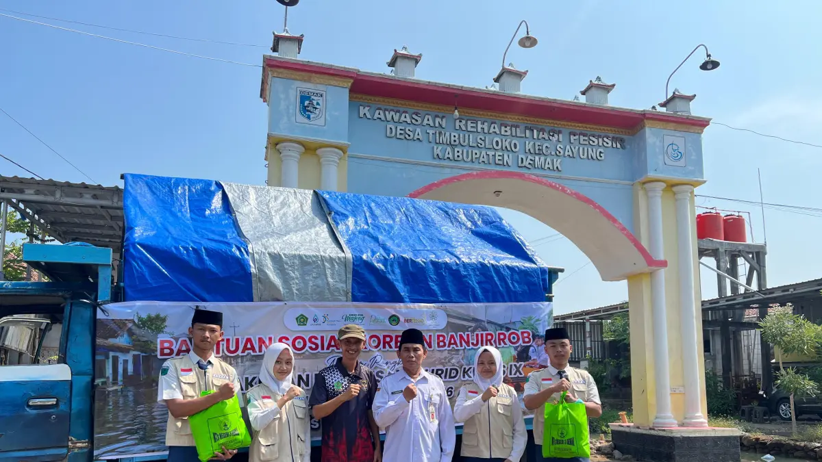 Kepala MTsN 3 Demak Ahmad Soleh dan siswa menyalurkan bantuan ke desa terdampak banjir rob Timbulsloko Sayung.(wahibpribadi)