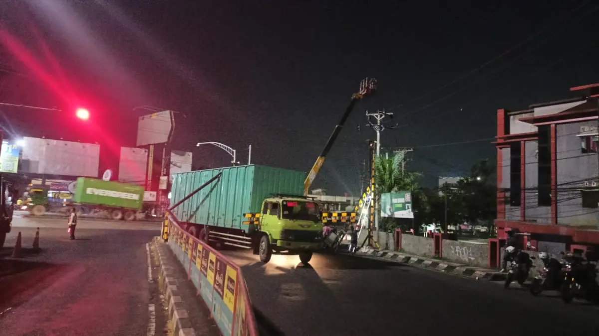 Petugas sedang melakukan pemotongan portal yang patah usai ditabrak truk tronton. ADENNYAR WYCAKSONO/ JAWA POS RADAR SEMARANG&nbsp;