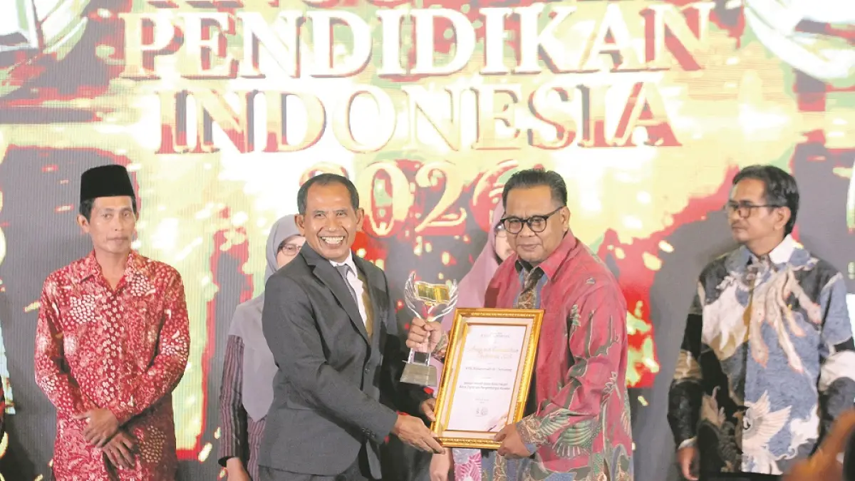 Kepala SMK Muhammadiyah 1 Semarang Lukman Hakim menerima penghargaan Anugerah Pendidikan Indonesia 2026 dari Direktur Jawa Pos Radar Semarang H. Baehaqi.&nbsp; (BASKORO SEPTIADI/JAWA POS RADAR SEMARANG)