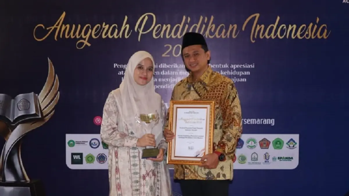 Pengasuh Pondok Pesantren Darul Amanah KH Muhammad Fatwa didampingi istri menunjukkan penghargaan Anugerah Pendidikan Indonesia 2026 dari Jawa Pos Radar Semarang. (LUTHFI HANAFI/JAWA POS RADAR SEMARANG)