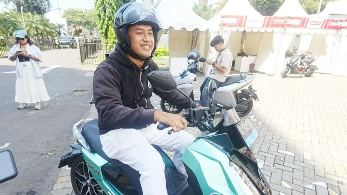 Ilustrasi :calon konsumen tengah mencoba salah satu motor listrik dalam sebuah pameran otomotif. (Jawa Pos)