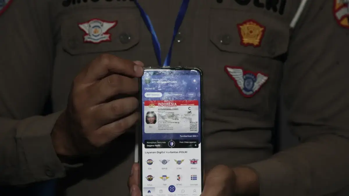Ilustrasi : Petugas Korlantas menunjukkan SIM Digital dalam smartphone. (Jawa Pos)