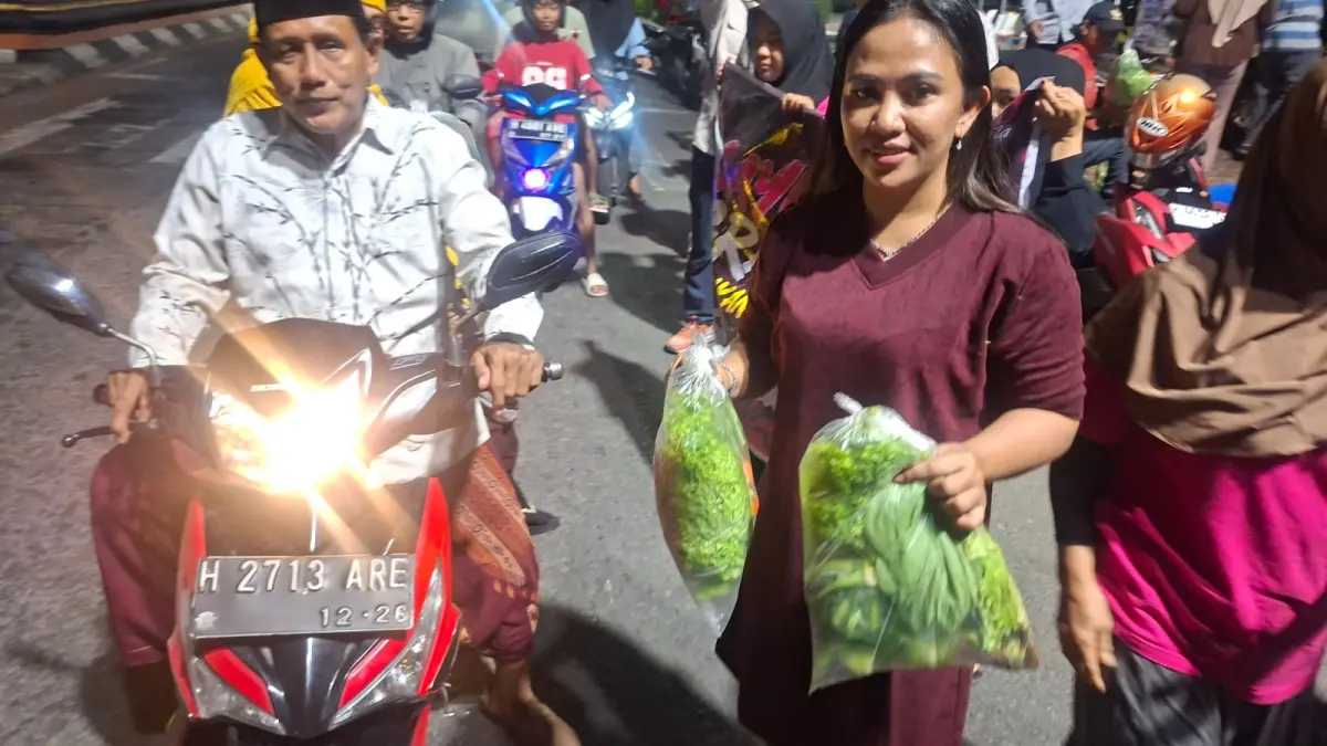 Ketua Tani Merdeka Demak Nur Ari Khasanah bersama relawan membagikan sayuran gratis ke pengendara motor.(Wahibpribadi)
