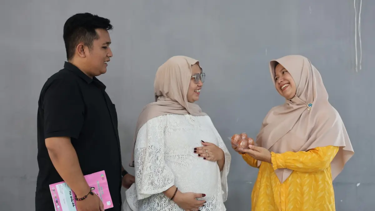 Ketua TP PKK Desa Pasinggangan Kartikawati (kanan) memberikan telur sebagai asupan gizi tambahan bagi ibu hamil pada Kelas Bapake Mamake di Banyumas.