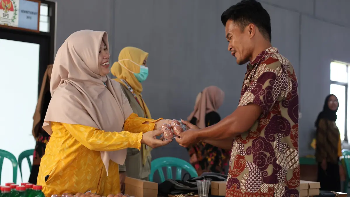 Ketua TP PKK Desa Pasinggangan Kartikawati memberikan telur untuk tambahan asupan gizi pada peserta Kelas Bapake Mamake di Balai Desa Pasinggangan.