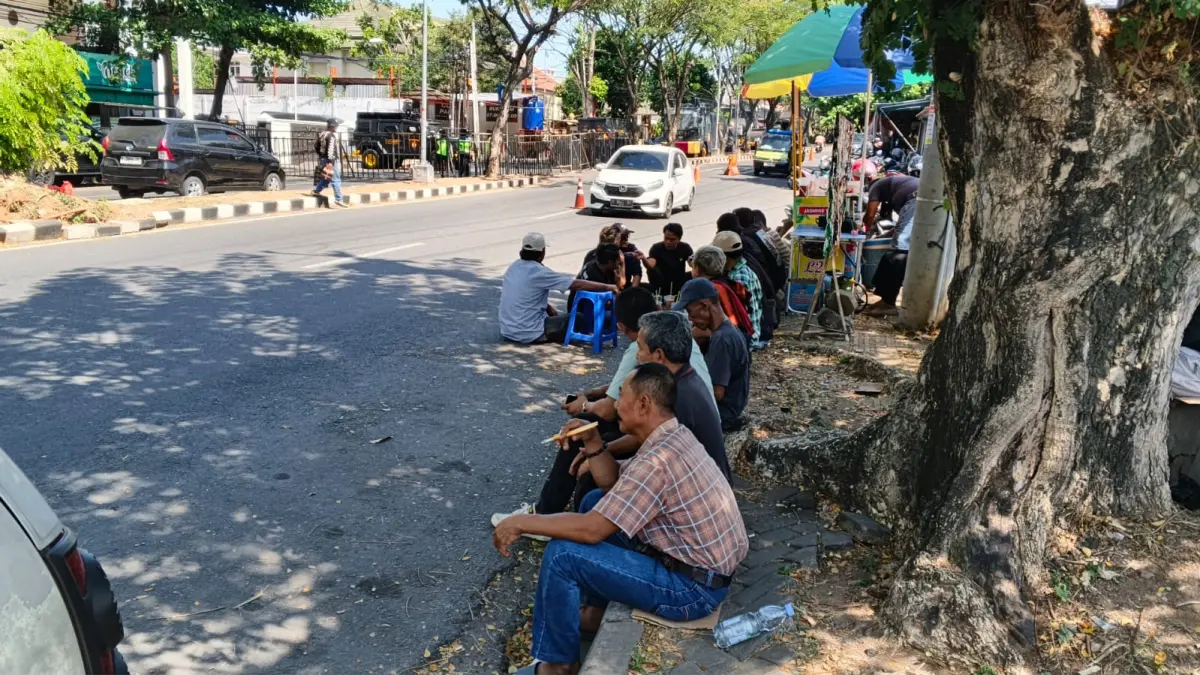 Massa pendukung Bupati Pati non aktif, Sudewo, terlihat hanya duduk-duduk diseberang kantor Pengadilan Semarang, Rabu (8/7/26). (Sulistiono)