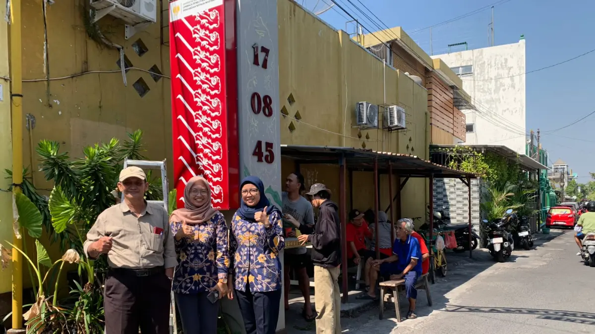 Dosen UNNES dan UNS melanjutkan rangkaian pengabdian berbasis seni di Kampung Blangkon Potrojayan, Surakarta dengan membuat mural di gapura.