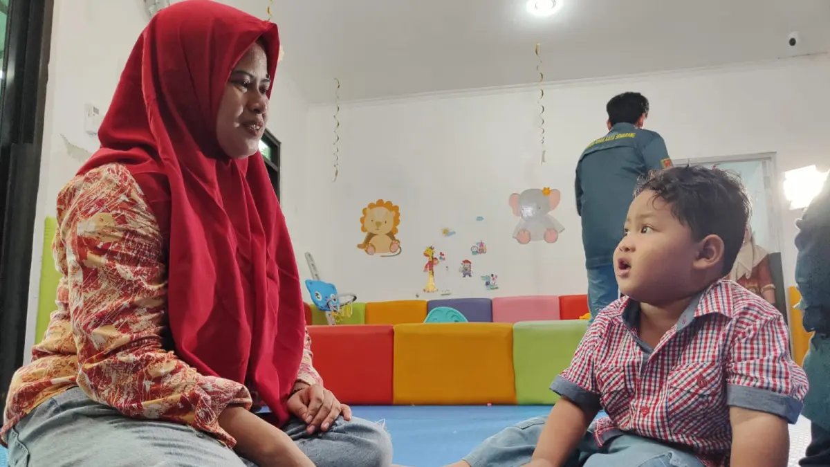 Nadhif ditemani ibunya sedang bermain permainan tradisional dakon di Rumah Anak SIGAP Kota Semarang.