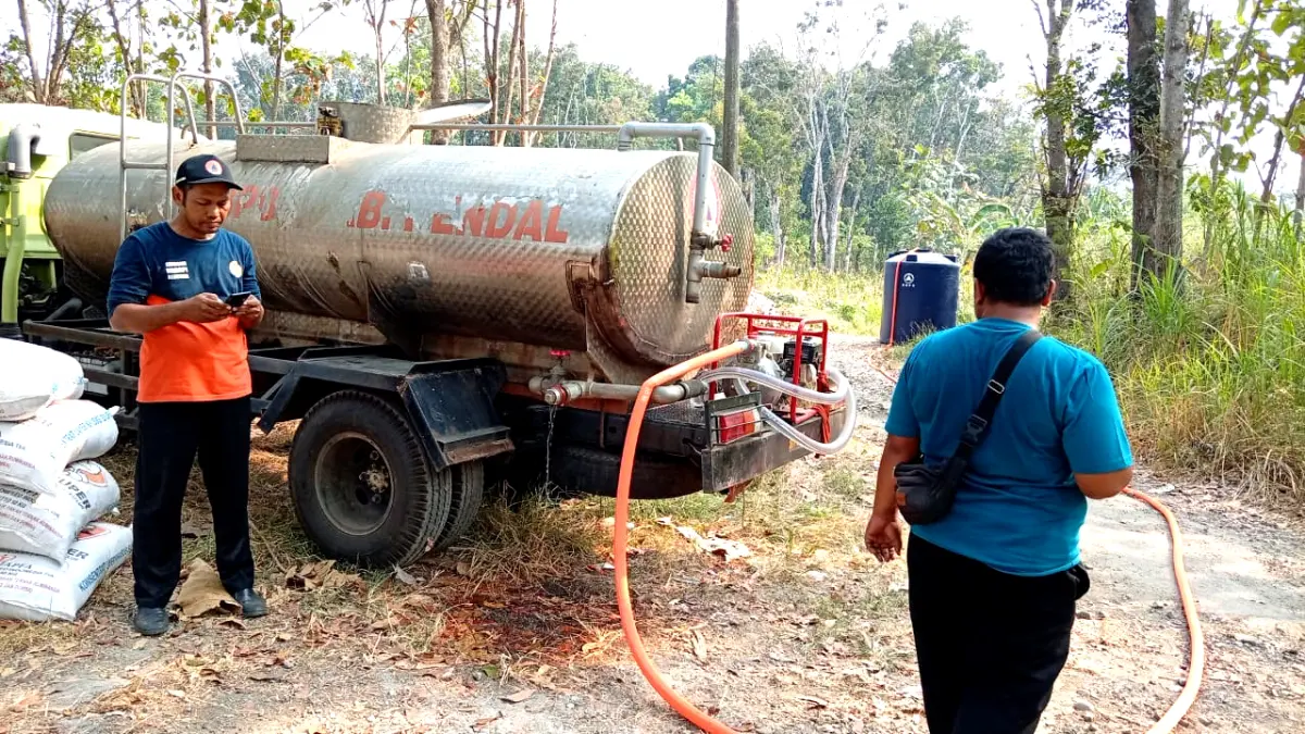 KIRIM AIR BERSIH: Petugas BPBD Kendal menyalurkan air bersih ke tandon warga di tengah kemarau panjang yang memicu kekeringan di sejumlah wilayah Kabupaten Kendal. (BUDI SETIYAWAN/RADARSEMARANG.ID)