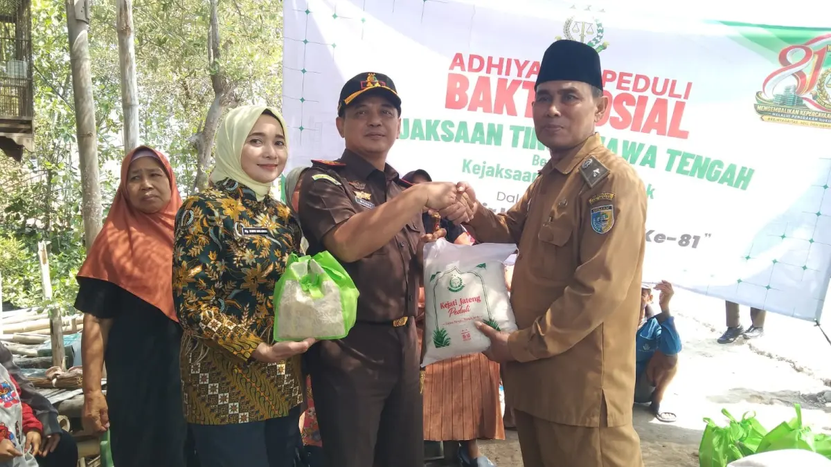 Kejari Demak Milono Raharjo SH dan istri menyerahkan bantuan korban rob di Timbulsloko Sayung dengan naik perahu. (Wahibpribadi)
