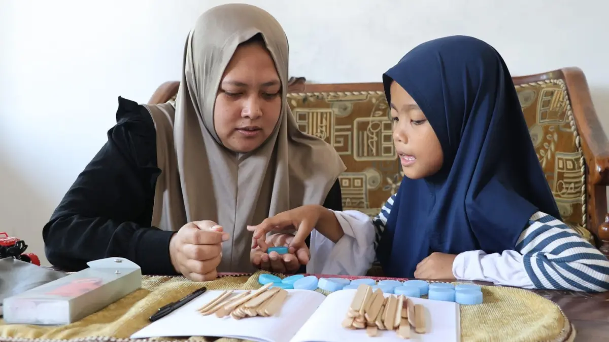 Zuni sedang mendampingi anaknya belajar.