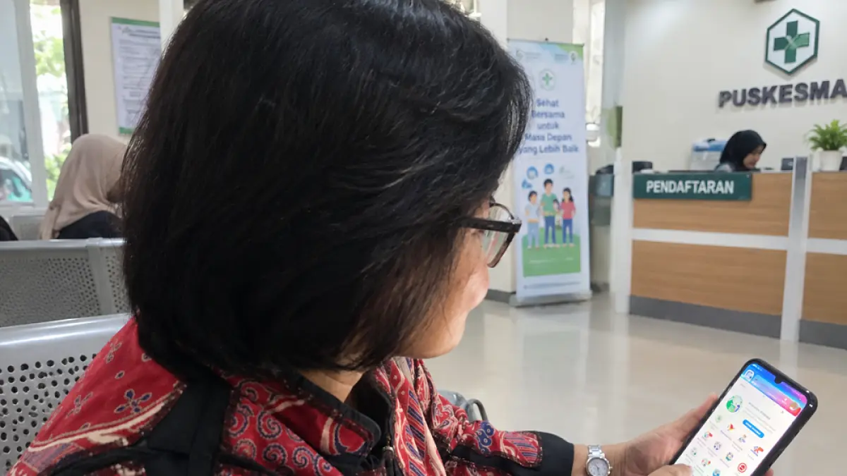 Dwiyanti menggunakan aplikasi Mobile JKN untuk mengambil nomor antrean di faskes yang akan ia tuju.