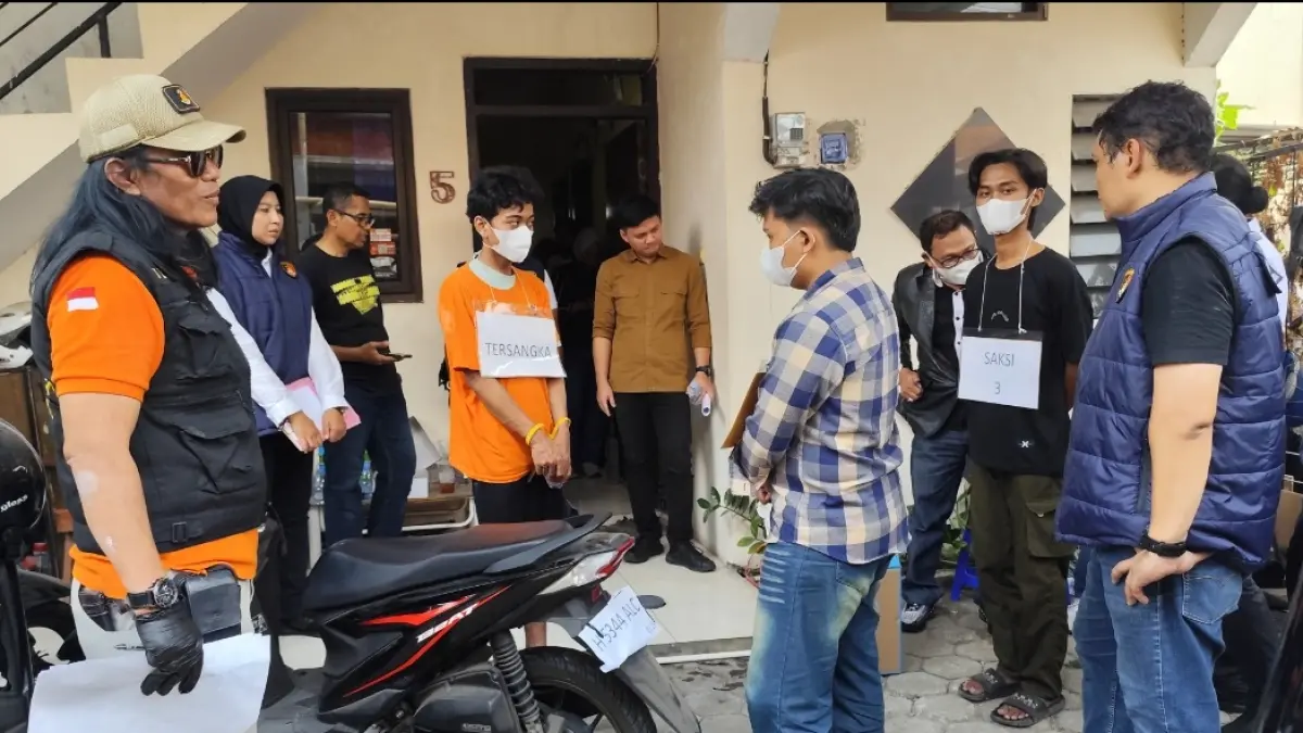 Tersangka memperagakan rekonstruksi cod motor korban Mozza yang dijual melalui media sosial Facebook