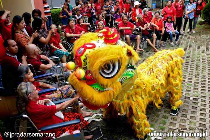 PEDULI LANSIA : Para lansia berusaha memberikan angpao kepada barongsai yang beraksi di halaman Panti Wredha Elim, Jalan Dr Cipto, Kota Semarang, Minggu (26/1).