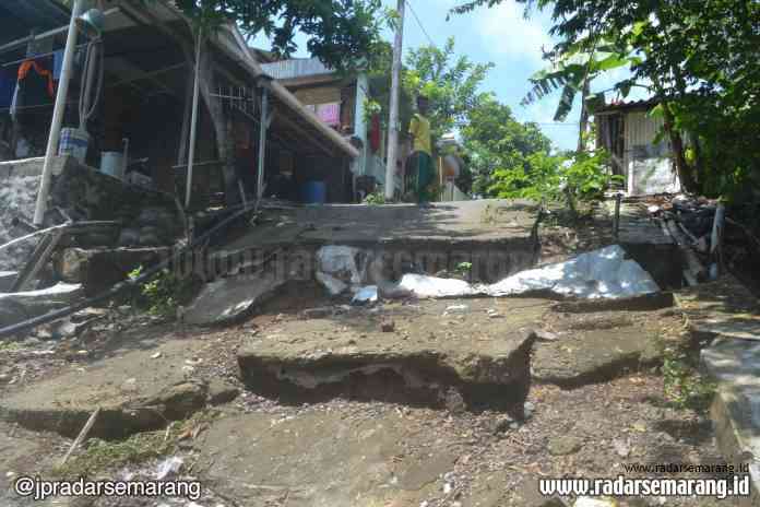 BERBAHAYA: Ketua RT 06 RW 10 Trangkil Baru Supriyono menunjukkan retak-retak di dinding toilet musala kampung setempat.