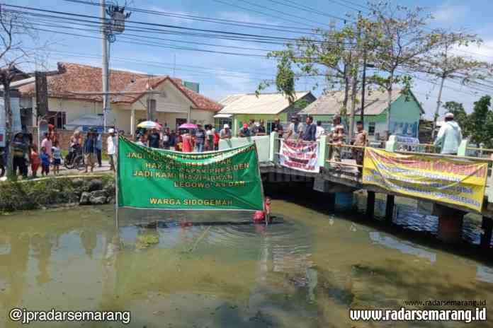 DEMO: Warga Desa Sidogemah, Kecamatan Sayung demo terkait belum tuntasnya pembayaran lahan tol. ( WAHIB PRIBADI/JAWA POS RADAR SEMARANG)