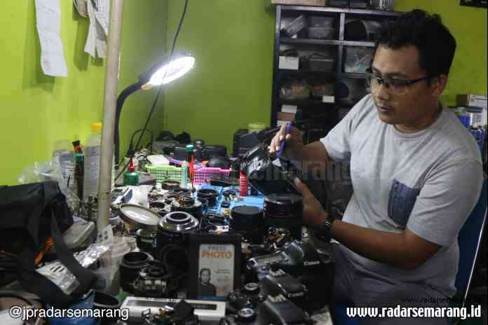 DOKTER KAMERA: Muhanif saat memperbaiki kamera di bengkel kerjanya.