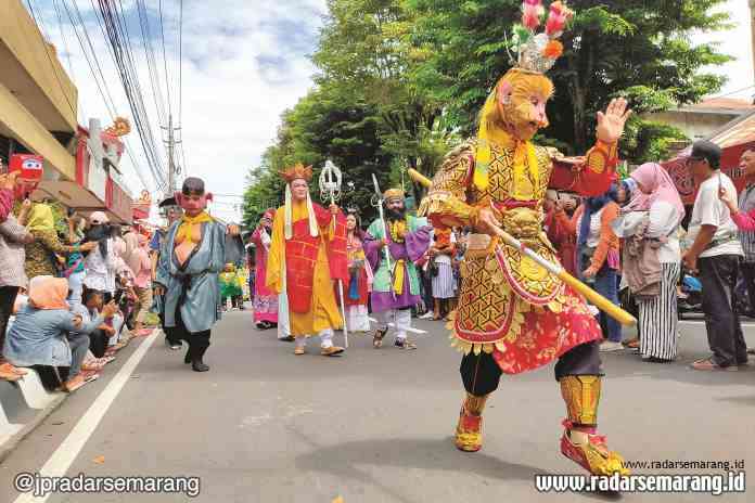 MERIAH : Peserta kirab Cap Go Meh dan seni budaya daerah hibur masyarakat Kota Magelang yang menonton di sepanjang Jalan Pemuda (Pecinan). (SATRIA BUDDA DELAPENA/RADAR KEDU)