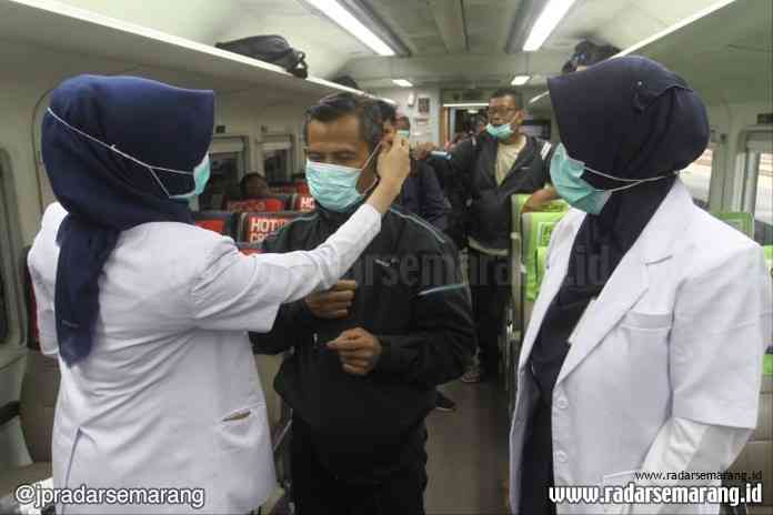 Petugas memperagakan cara penggunakan masker kepada penumpang. (Adityo Dwi)