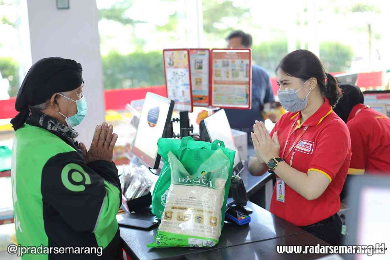 Mitra driver Gojek sedang menukarkan voucher sembako gratis di salah satu gerai Alfamart. (Istimewa)