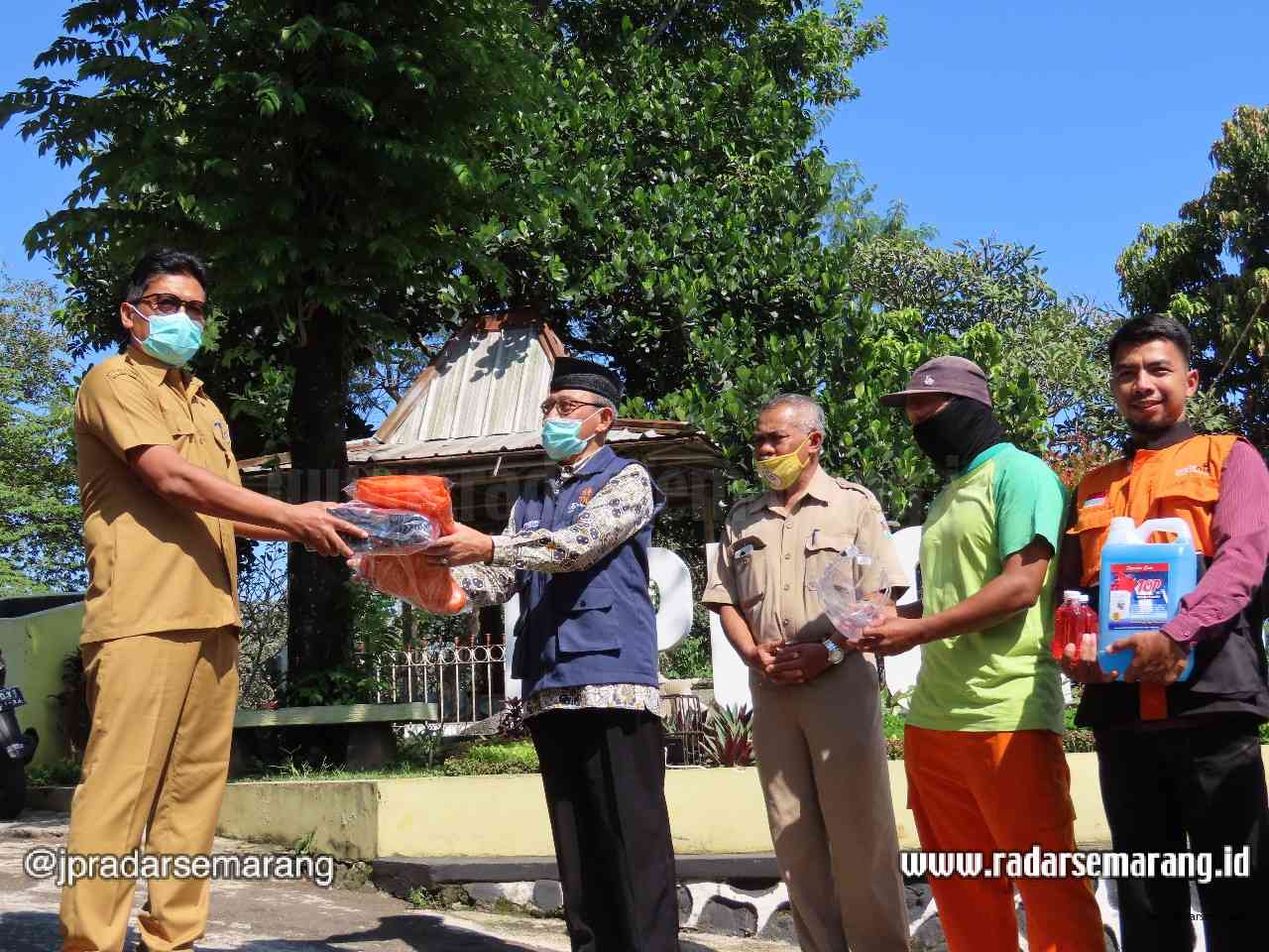 Ketua PD Muhammadiyah Kota Magelang Solichin menyerahkan APD kepada Plt Dinas Lingkungan Hidup Kota Magelang Otros Trianto Senin (13/4/2020).  (Istimewa)