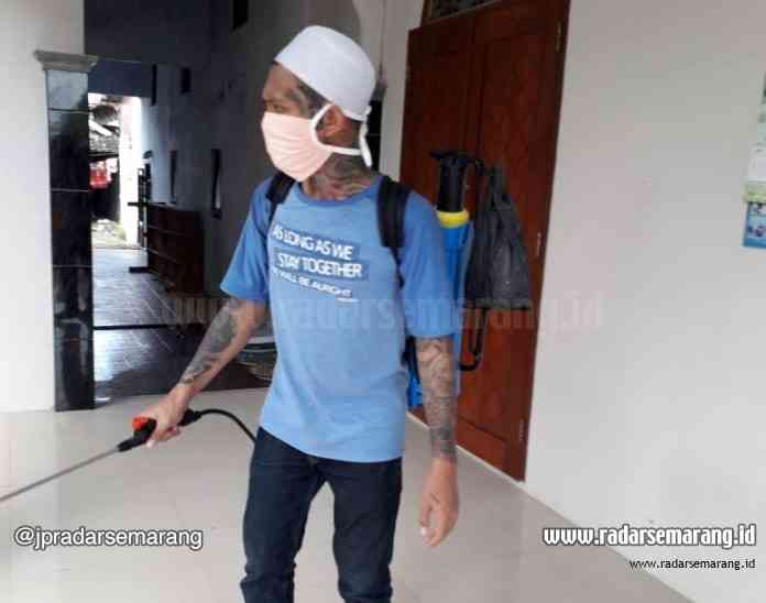 Mantan napi penuh tato sedang melakukan penyemprotan dj Musala Nurul Huda, Kabupaten Batang. (Istimewa)