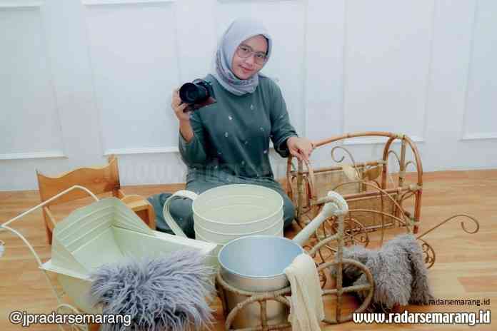 Kinanthi Putri dengan sejumlah peralatan yang biasa ia gunakan untuk memotret bayi. (Kinanthi Putri for Jawa Pos Radar Semarang)