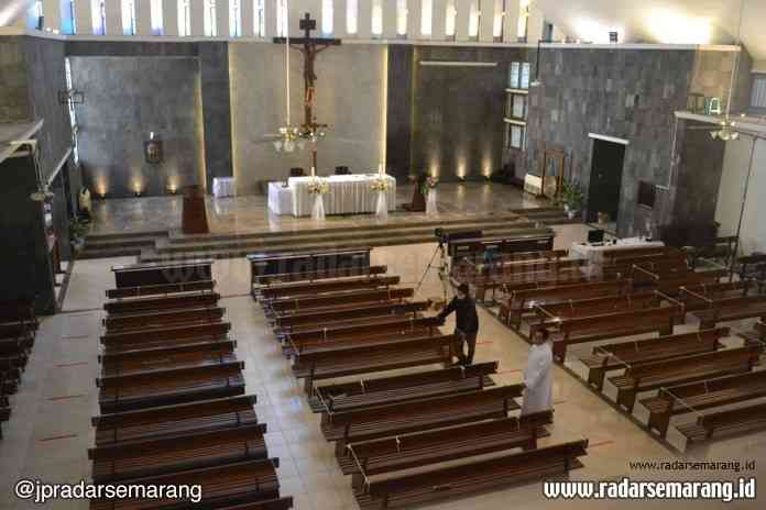Pastor Kepala Paroki St Theresia Bongsari, Romo Eduardus Didik Chahyono SJ melihat bangku tempat duduk umat yang telah diberi batas dengan tali di Gereja Bongsari, Minggu (28/6/2020). (Nurchamim/Jawa Pos Radar Semarang)